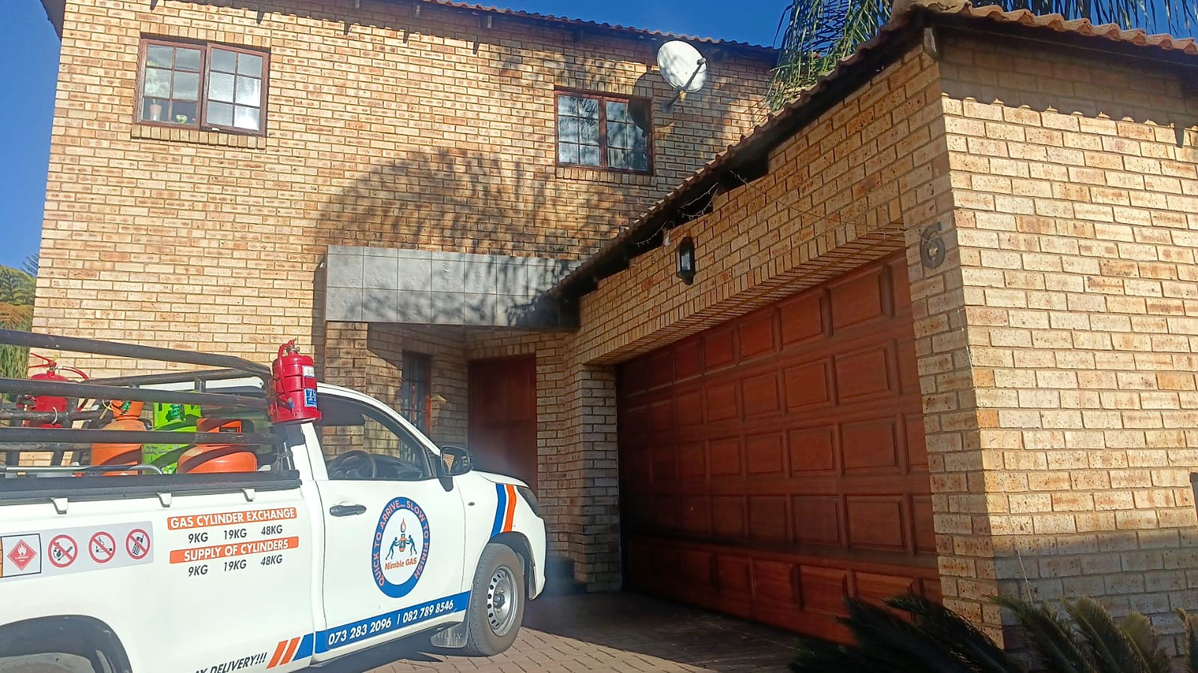 Nimble Gas bakkie loaded with LPG cylinders, parked outside a customer's home